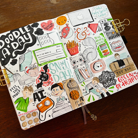 Open notebook with completed Doodle A Day collage spread