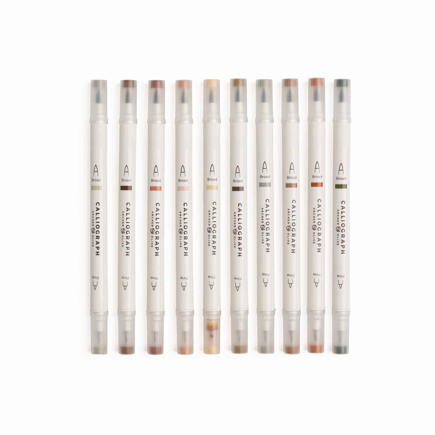 Set of ten Quiet Corners calligraphy pens with flexible brush tips laid out with lettering samples