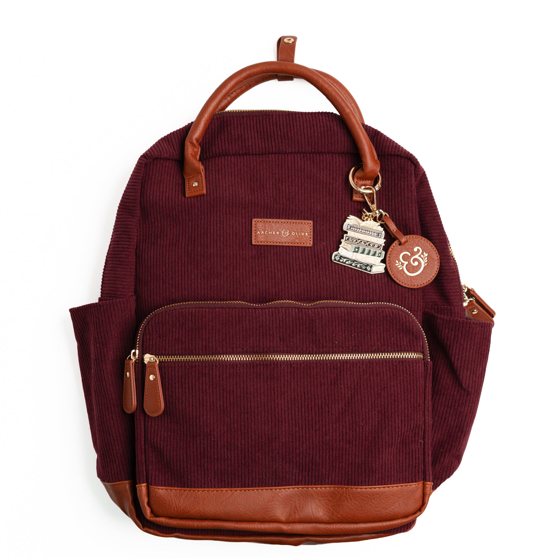Maroon ribbed corduroy backpack with brown vegan leather trim and book-stack keychain