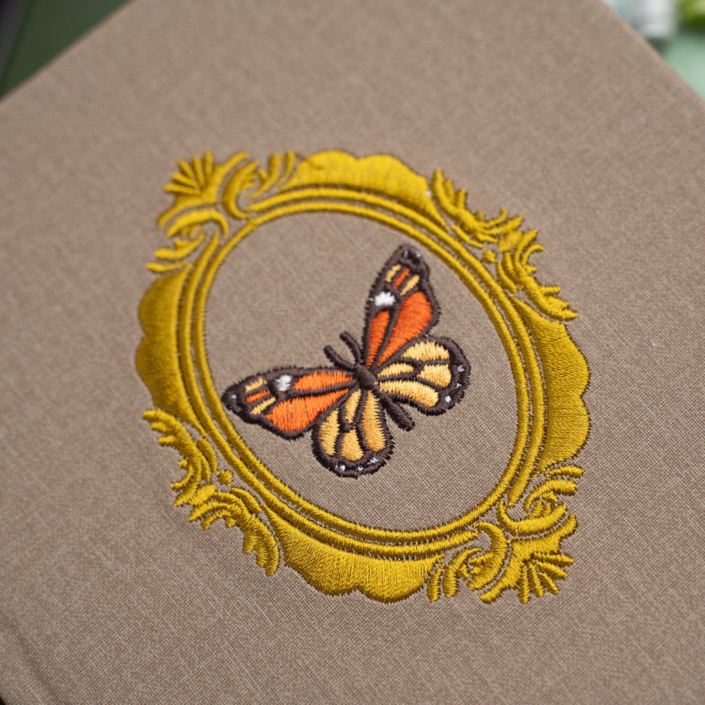 Embroidered butterfly design on a brown fabric background