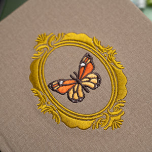 Embroidered butterfly design on a brown fabric background