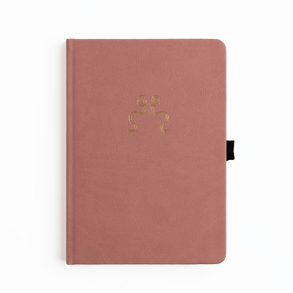 Pink notebook with a gold emblem on a white background