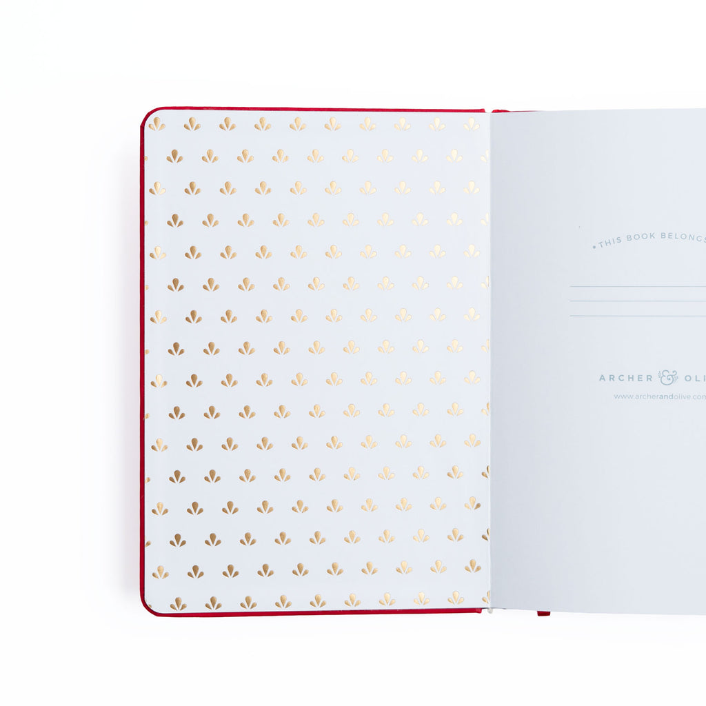Open notebook with gold dot pattern on white pages, brand 'Archer & Olive' visible.