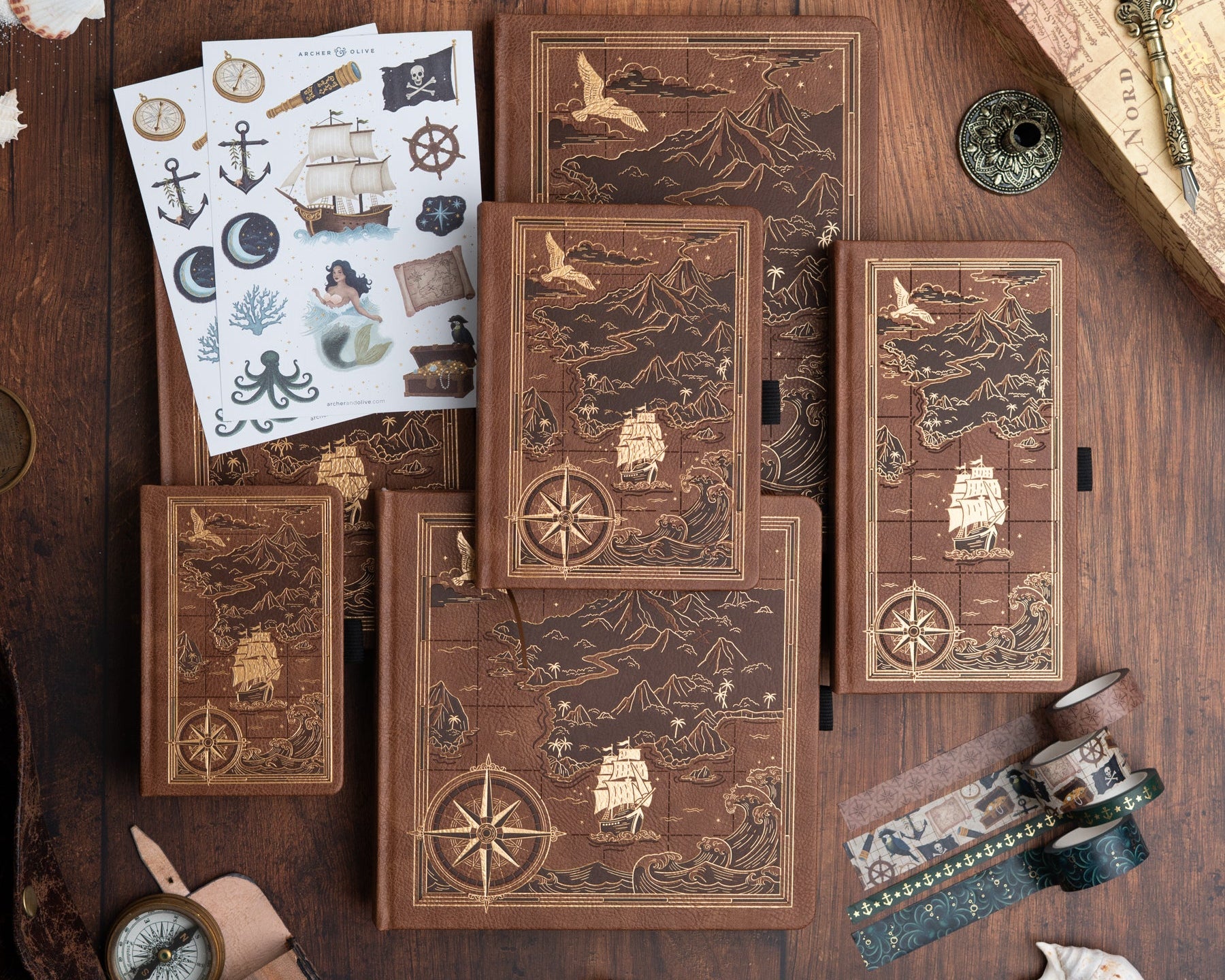Collection of wooden journals with nautical designs on a wooden surface.