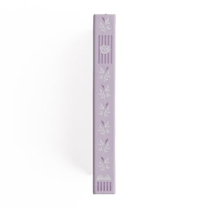 Lavender-colored decorative item with leaf patterns on a white background