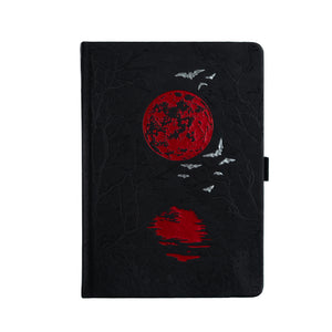 Black notebook with red moon and bird design on a white background