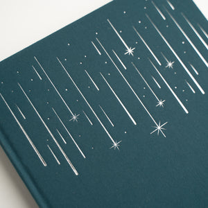 Teal notebook with white star and line pattern on a white background
